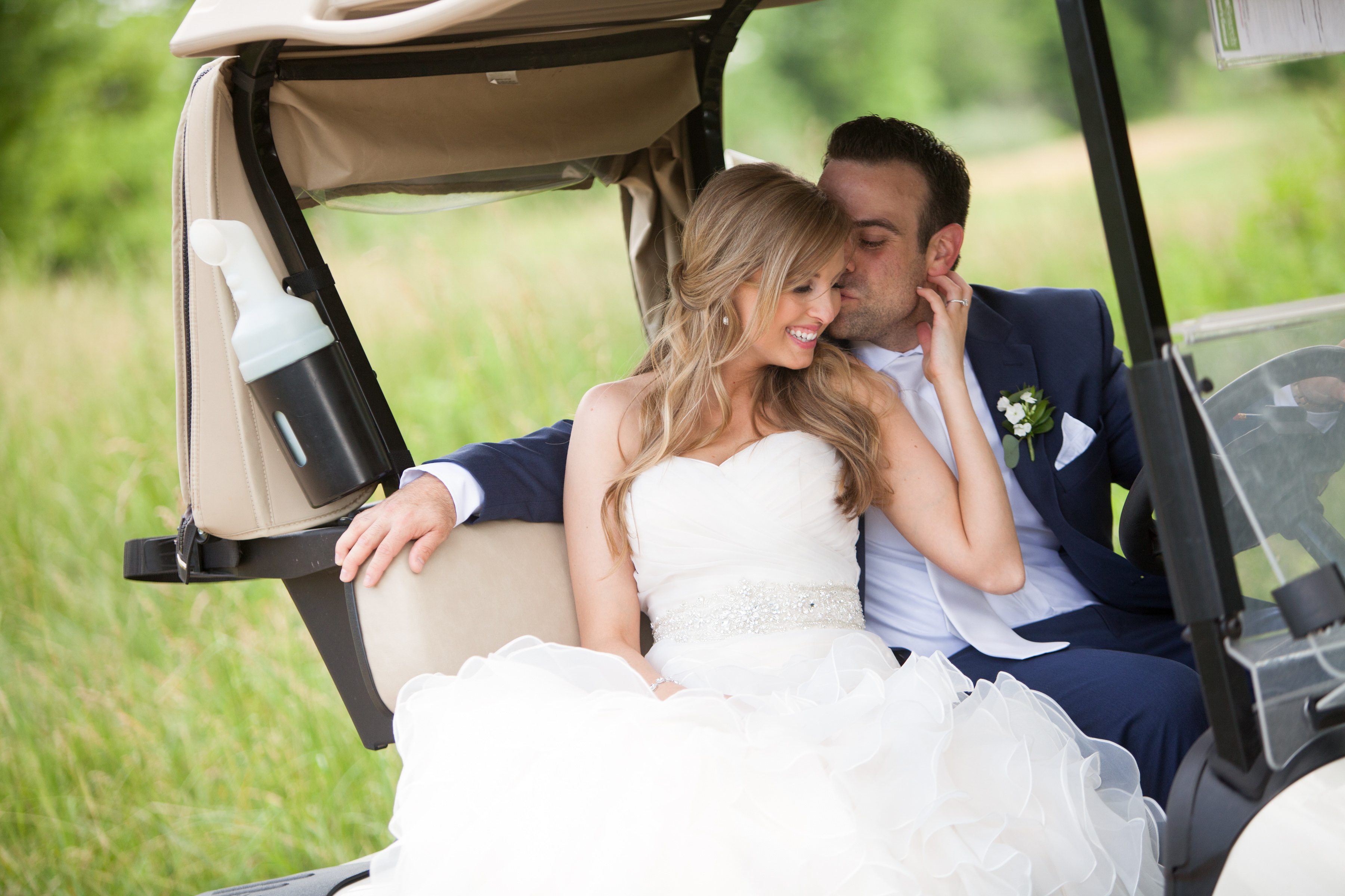 Liz & Jay: Country Club Wedding, groom kissing bride on golf cart